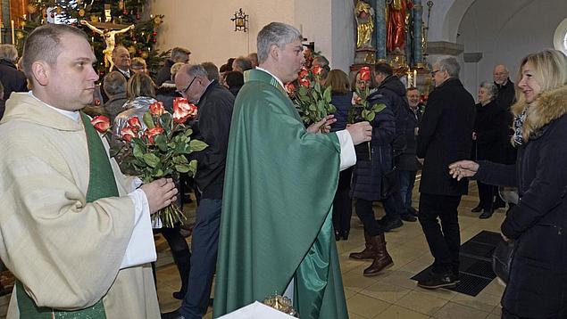 Pfarrer Roland Seger und Diakon Andreas Lerch (li.) überreichen die Rosen
